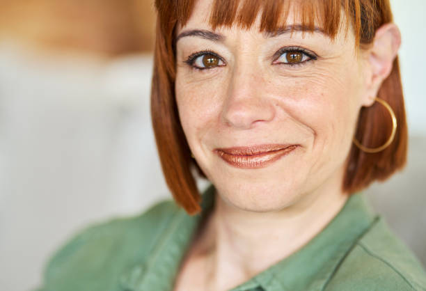 istock Woman smiling while sitting on her living room sofa 1481684222