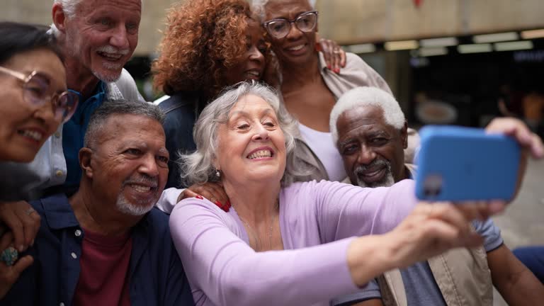 Senior friends taking selfies on the mobile phone in the street