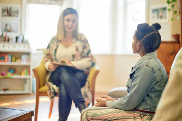 Psychologist, black girl and consultation in office for support, help or mental health. Psychology, therapist or kid or child consulting woman for counselling, therapy or talking for advice in clinic stock photo