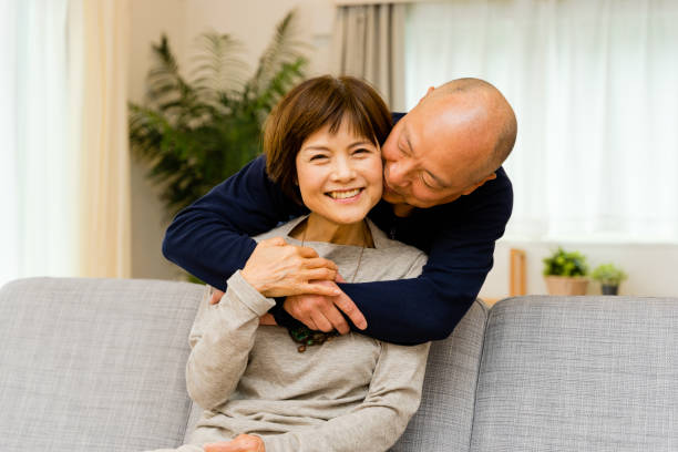 istock Husband hugging from behind to a wife sitting on the sofa (expression of a senior couple) 1481694507