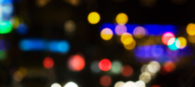 Blurred multicolored night city lights, cityscape. Image suitable for night city life or traffic background, copy space on the right.