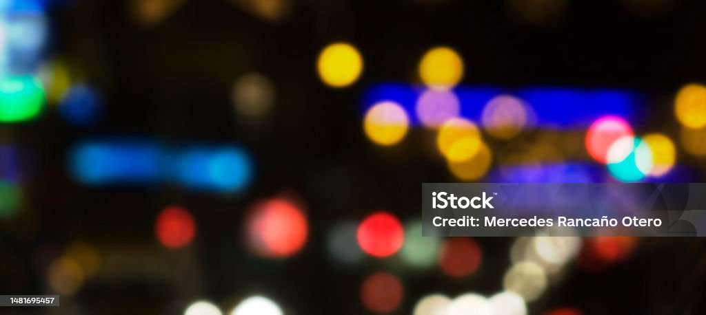 Blurred night street light dots. Blurred multicolored night city lights, cityscape. Image suitable for night city life or traffic background, copy space on the right. Defocused Stock Photo