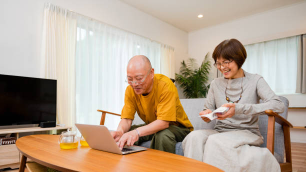 istock Using a computer at a living table at home, a senior couple in their 50s and 60s 1481695708
