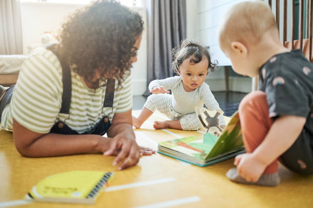 baby-sitter, bébés et apprentissage avec livre à la maison, contes et éducation à la maison. développement, soins et lecture de nounou avec les enfants, les enfants ou les tout-petits tout en créant des liens et en s’amusant ensemble. - male nurse nurse aspirations learning photos et images de collection