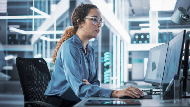 istock Happy Multiethnic Female Industrial Engineer Developing 3D Model of a Circuit Motherboard on Computer CAD Software in a Startup Facility. Modern Technological Research and Development Center. 1481701769