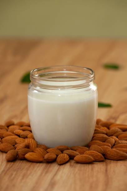 istock Vertical shot of a jar of milk on a table surrounded by almonds 1481701873