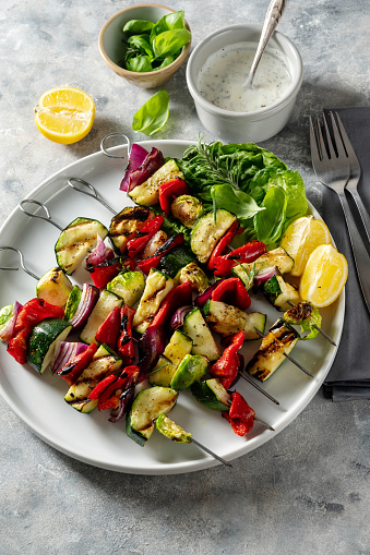 Grilled vegetable kebabs, skewers with zucchini, bell peppers, bruxelle cabbage and red onions