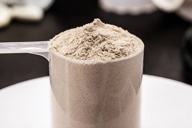 istock Measuring spoon with creatine or whey, on precision scale, preparing food supplement or casein cocktail, muscle mass vitamin 1481709765