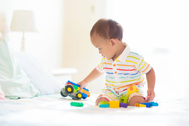 istock Baby boy playing on bed in sunny nursery 1481712029