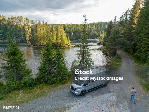 istock Man walks towards his van parked by the lake, drone view 1481712101