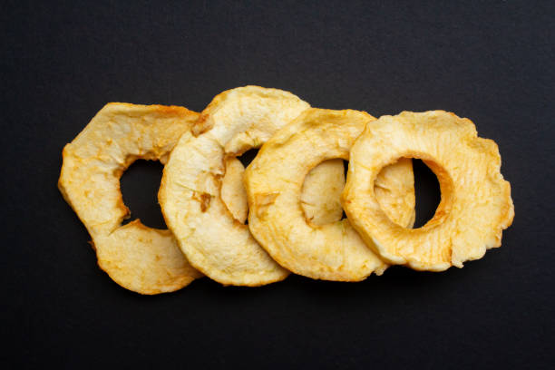 istock Dried apple slices on a isolated black background 1481712339