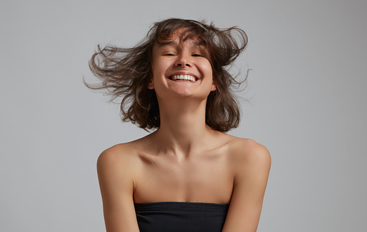 Portrait of smiling young woman with flying hair.