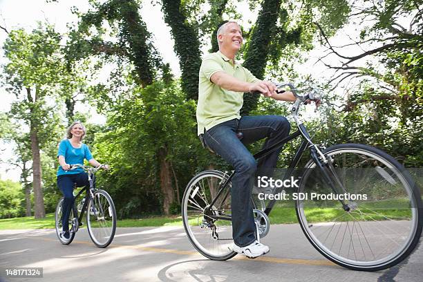 Adulto In Età Matura Coppia Bike Su Un Sentiero - Fotografie stock e altre immagini di Adulto - Adulto, Adulto in età matura, Albero