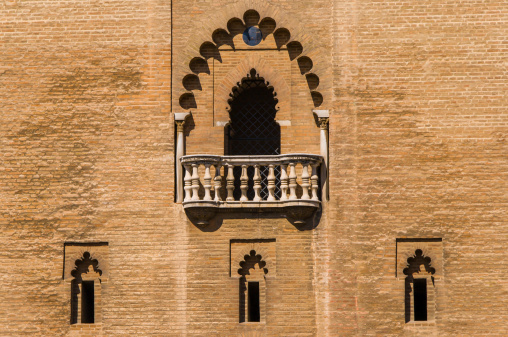 Arabic-style wall with 3 windows and one open balcony above.