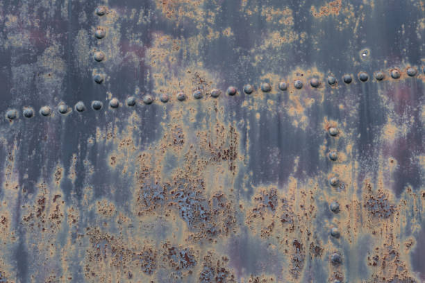 istock Scratched, stained, rusty sheet metal plate with rivets background texture 1481716214