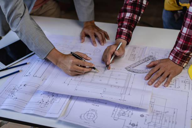 istock Engineer pointing at blueprint and using laptop to draw project design building construction architect Contractor and foreman meeting with floor plan for real estate development project industry 1481720188