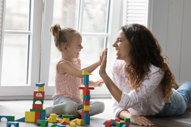 istock Cheerful mom and kid girl clapping hands, giving high five 1481721816