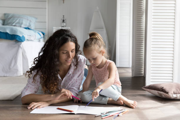 istock Mom engaging little kid into creative hobby, resting on floor 1481721846