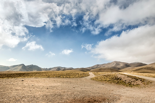 A field road ascending into a hollow between the mountains. Altai, Siberia, Russia.