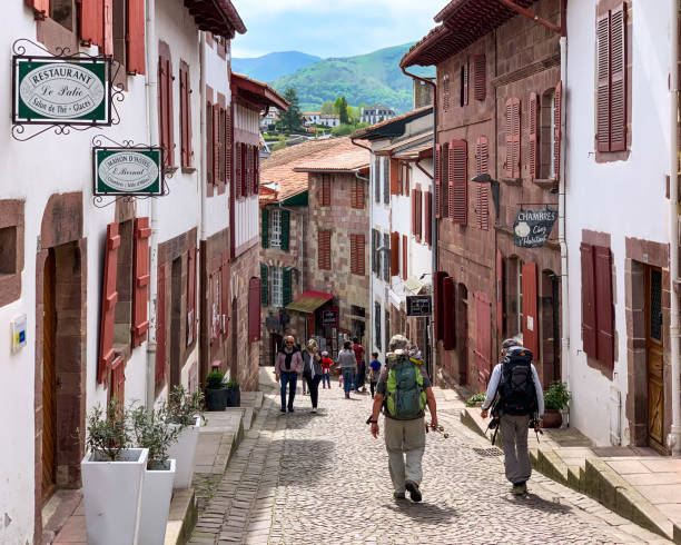 Pilgrims to Compostela in French village Saint-Jean-Pied-de-Port in French Pyrenees near Spanish border, the starting point of the French Way (Camino Francés), the most popular option of Camino de Santiago pilgramage saint jean pied de port stock pictures, royalty-free photos & images