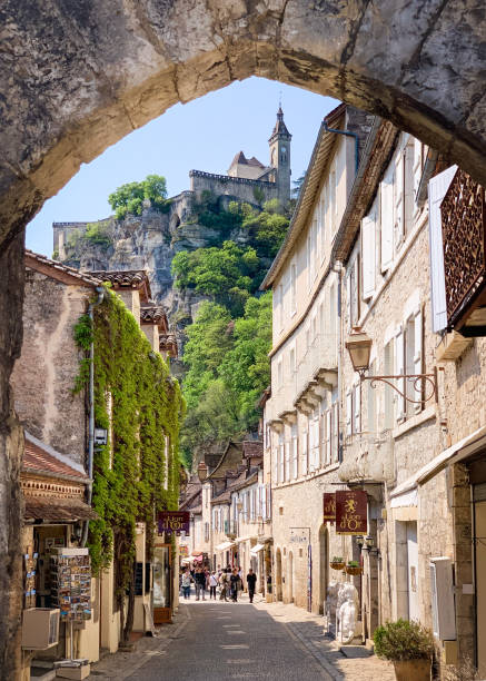 Rocamadour main street with castle Picturesque medieval pilgrimage town Rocamadour in Southwestern France famed for its goat cheese store wall surrounding wall facade stock pictures, royalty-free photos & images