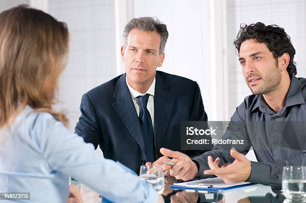 Two Men And A Woman Talking In A Business Meeting Stock Photo - Download Image Now - Clipboard, Interview - Event, Women