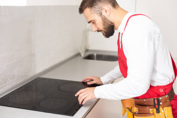 istock Man electrical repairs kitchen surface apartment. Installing hob in countertop. Man bought new kitchen furniture and appliances. Process installing an electrician household appliances. 1481732295