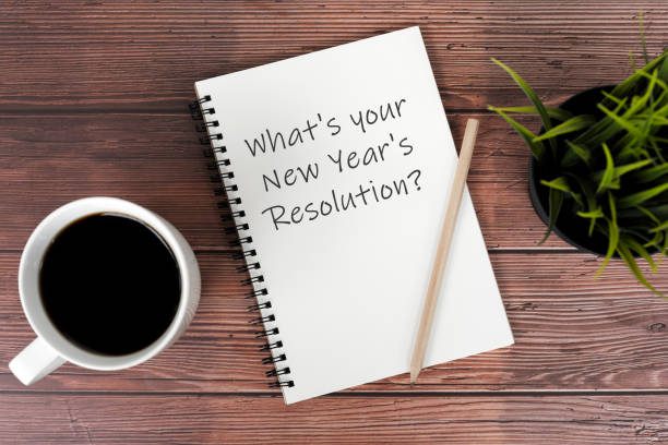 istock Cup of coffee and notepad with text What's your New Year's Resolutions 1481736507
