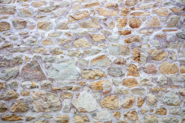Old stonewall empty beige with white cement background texture. Vintage rough stone wall, blank masonry or floor backdrop. Copy space.