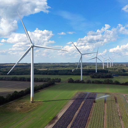 Aerial view of power generating windturbines on a sunny day in  Denmark