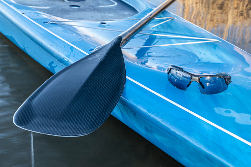 wet paddle and sunglasses on a deck of stand up paddleboard