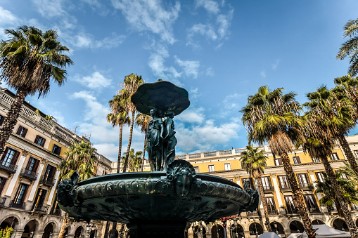 Fuente de las Tres Gracias at Famous Royal Plaza With Palm Trees In Barcelona, Spain