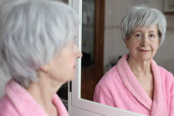 istock Cute senior woman looking at her reflection in the bathroom 1481748170