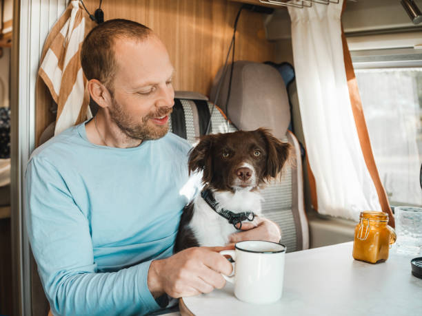 istock Man and his dog in a camper van drinking coffee out on adventure 1481748797