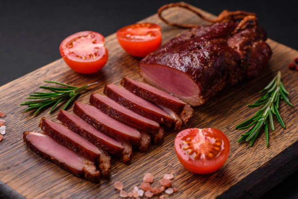 Delicious duck fillet or breast grilled or smoked with spices and salt Delicious duck fillet or breast grilled or smoked with spices and salt on a dark concrete background duck meat stock pictures, royalty-free photos & images