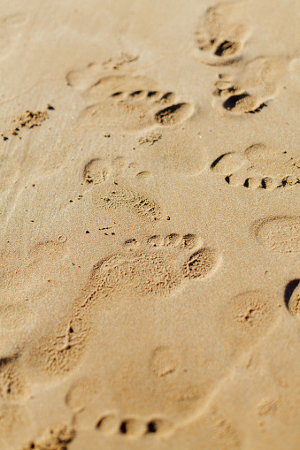 Background concept of footprints on a sand on the beach