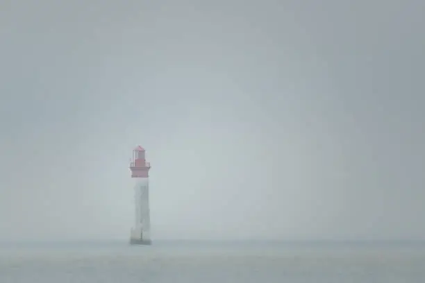 Photo of Chauveau lighthouse, isle of Re, at low tide on a foggy day