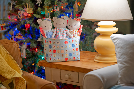 A basket by a country cottage Christmas Tree  containing three home made teddy bears