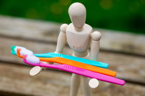 istock Multi-colored toothbrushes in the hands of a human figure. Cleaning and caring for teeth concept. 1481752911