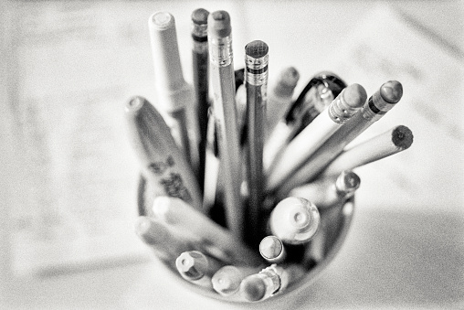 An array of pencils and pens in a desktop canister