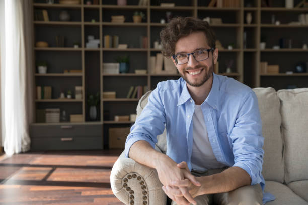 istock Happy handsome business man in glasses sitting on couch 1481755876