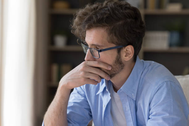 istock Thoughtful serious man sitting on coach at home 1481755878