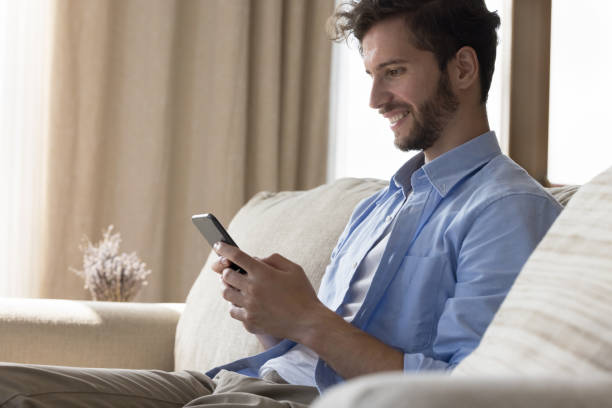 istock Happy handsome young man browsing Internet on mobile phone 1481756009