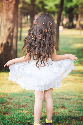 Cute little girl in orange dress posing over white background. Little princess girl portrait