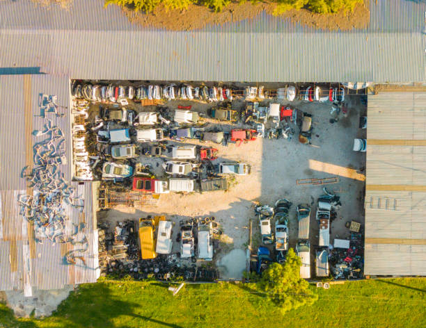 aerial view car junkyard. Stacked cars and street. Drone shooting. Primitive industrial site.