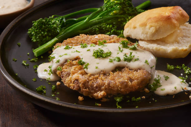Chicken Fried Steak Chicken Fried Steaks with Country Style Gravy, Broccolini and a Biscuit chicken fried steak stock pictures, royalty-free photos & images