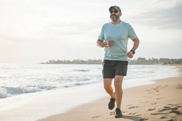 man walking and doing sports on the beach stock photo