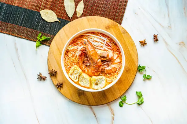 Tiger Prawn Laksa noodles served in bowl isolated on wooden board top view on marble background hong kong food