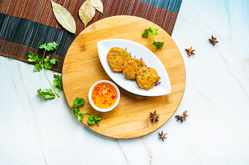 Deep-fried Fish Cake with chilli sauce served in dish isolated on wooden board top view on marble background hong kong food