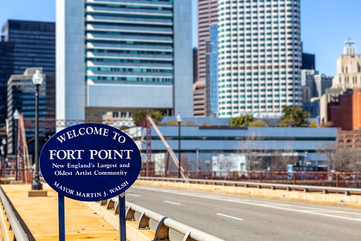 Boston, Massachusetts, USA - April 9, 2023: Welcome to Fort Point sign on the Summer Street bridge over the Fort Point Channel. The Fort Point Channel is a maritime channel separating South Boston from downtown Boston. \nThe Fort Point neighborhood is known as an artists' community. Selective focus.